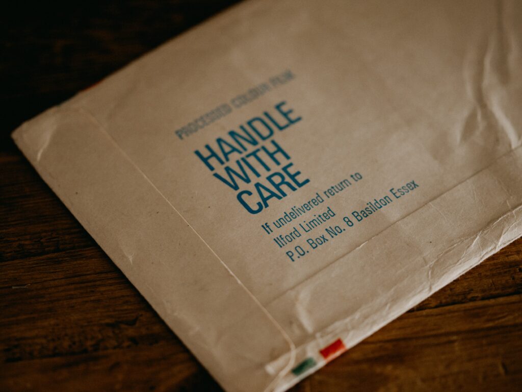 An envelope with "handle with care" written on it